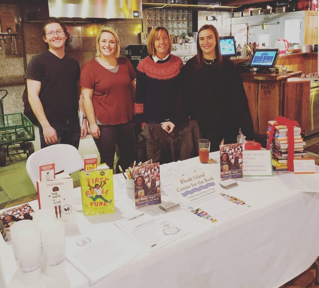 People smiling standing behind benefit table